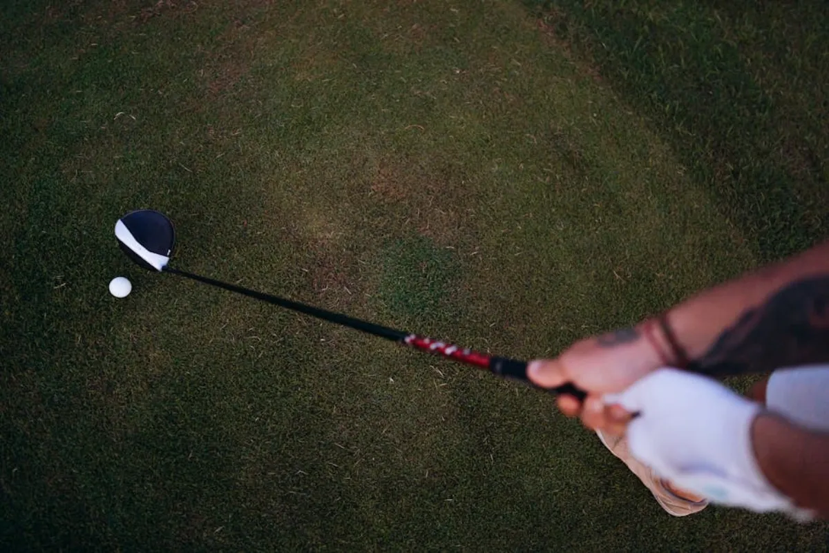 Golfer experiencing medial epicondylitis during a swing