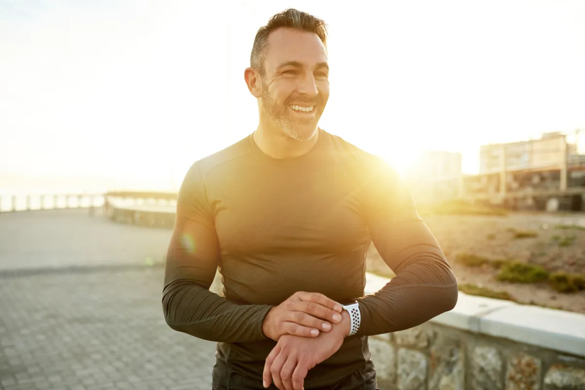 Fit man smiling outdoors after workout