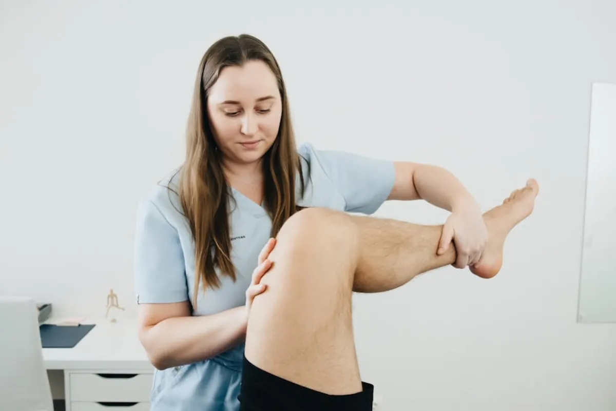 Physical therapist examining knee for patellar tendinopathy